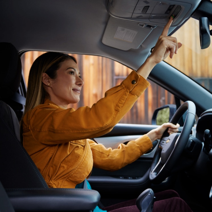 Mujer dentro de un vehículo Chevrolet activando la tecnología OnStar